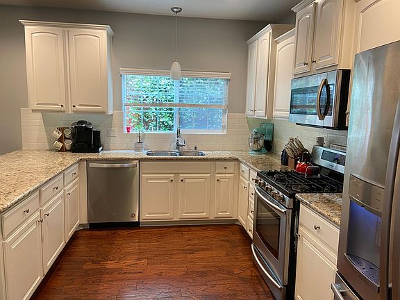 Beautiful kitchen with stainless steel appliances, gas range, and granite countertops with eat-in bar.