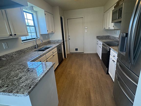 Updated kitchen featuring brand-new granite countertops, Samsung refrigerator, dishwasher, and stove. Complemented by ample cabinet space for all your kitchen essentials and pantry with shelving.
