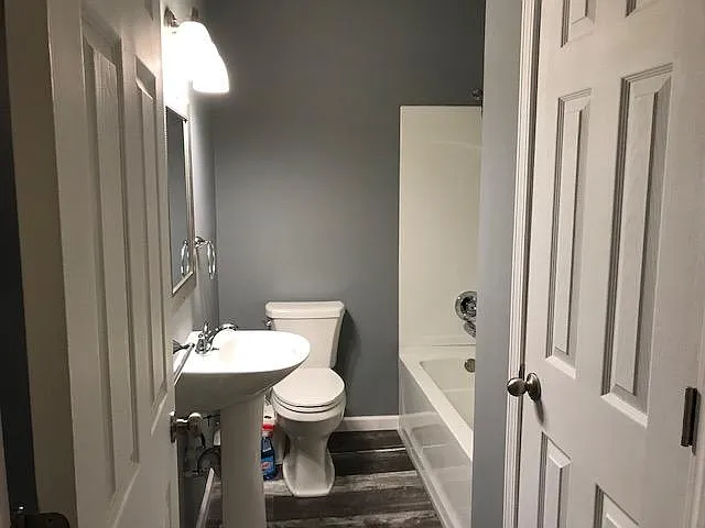 Full bathroom. Large storage closet to right with panel door.