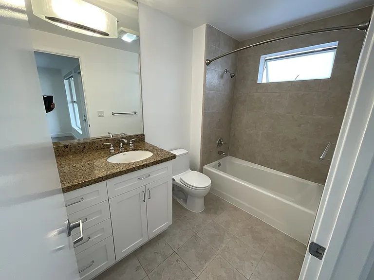Primary suite bathroom with shower over tub and dual sinks.