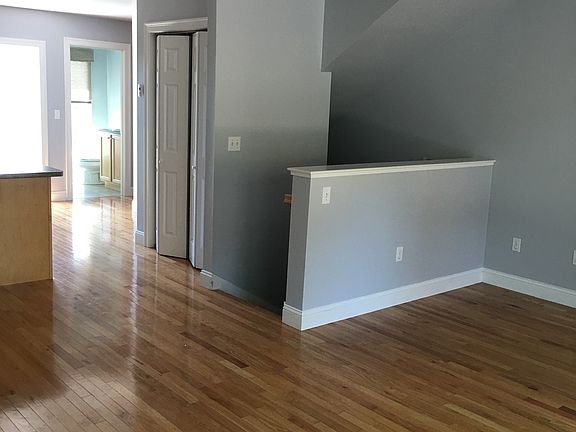 Living area looking into kitchen. Food storage closet. Stairs lead to front entrance and garage access.