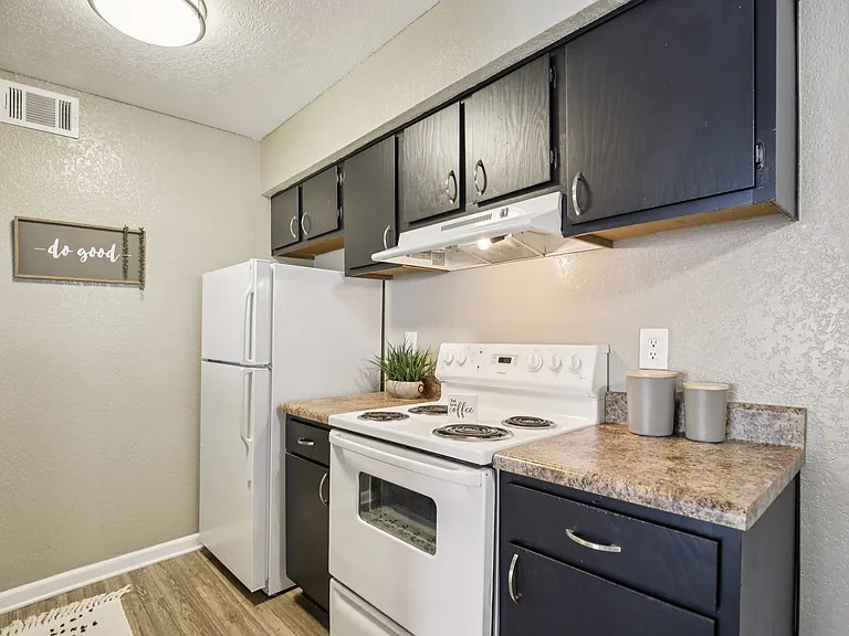 Kitchen with cabinets and drawers, range and refrigerator.