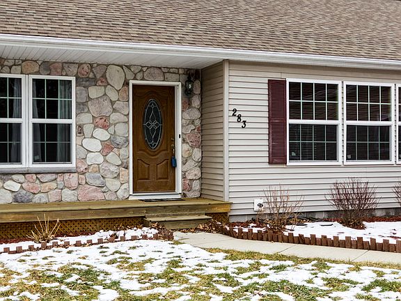 The front of the house shows the nice stone and vinyl siding and a nice front deck tosit and relax on your beautiful summer days...