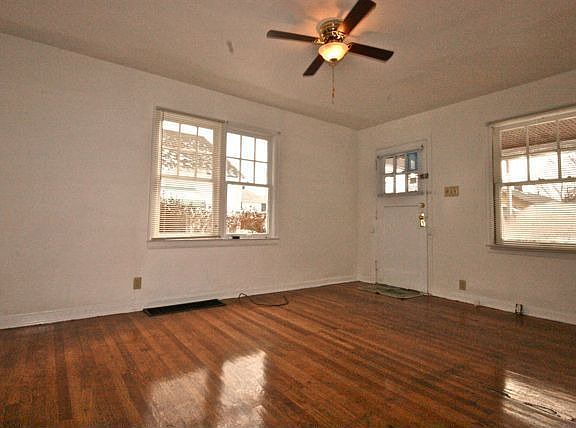 Large Family Room with original hardwood floors, plenty light, ceiling fan