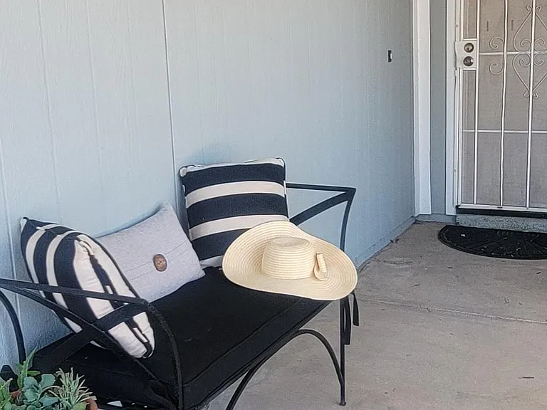 Home includes this wrought iron outdoor bench, cushions, and table.