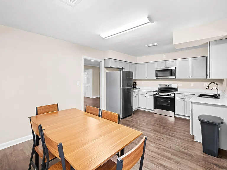 Open kitchen with ample cabinetry, full appliance suite, and adjacent dining area with space for a table and chairs.