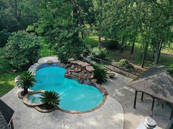 View of the backyard with pool, hot tub and pergola.