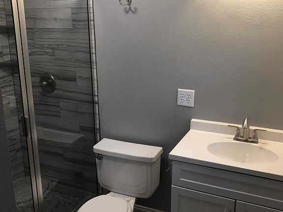 master bath with custom shower and glass enclosure. new toilet and vanity with new fixturesz and new mirror not pictured.