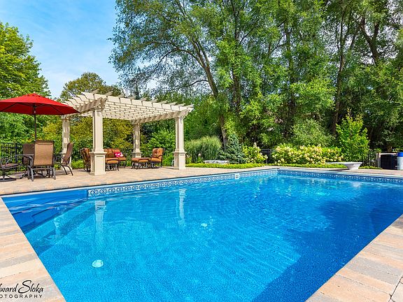 THIS WONDERFUL OUTSIDE AREA OFFERS IN GROUND POOL WITH AUTOMATIC COVER, WATER FALL AND NUMEROUS GATHERING AREAS.