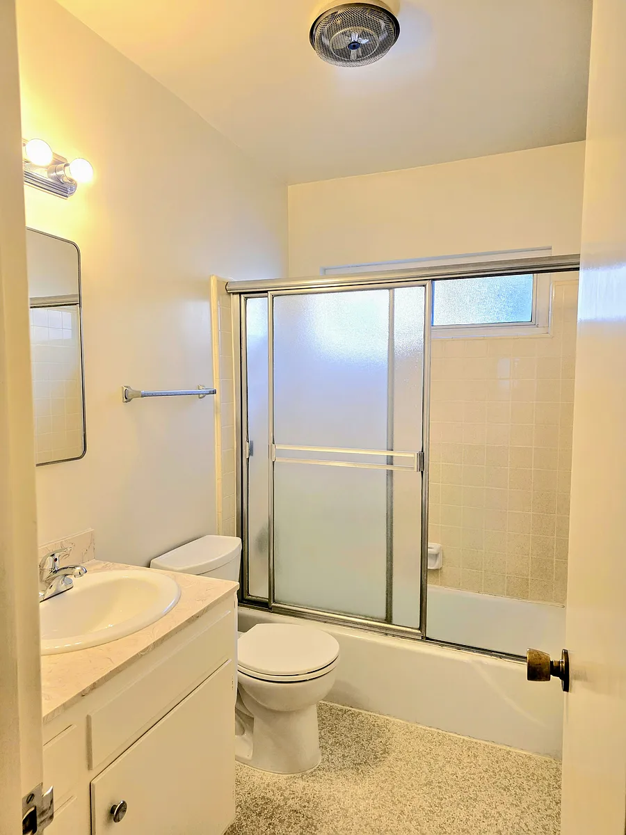 Bright, clean bathroom with sliding glass doors, window, air fan, medicine cabinet and more storage! - 129 N Lamer St