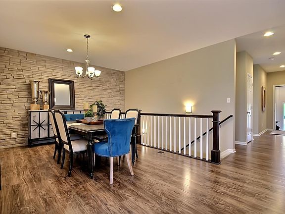 VIEW OF LARGE DINING ROOM W/STONE WALL & BEAUTIFUL RAILING LEADING TO FULL BASEMENT!  LOADS OF SPACE FOR ENTERTAINING!