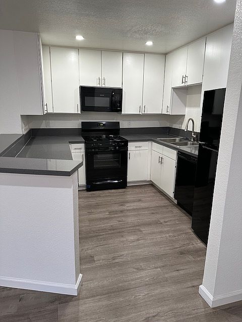 Large updated kitchen with refrigerator, gas range, oven, microwave, dishwasher, and garbage disposal.