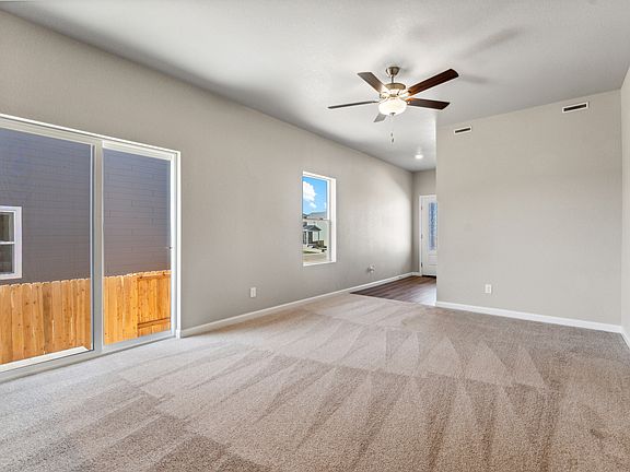The family room is spacious and has a ceiling fan.