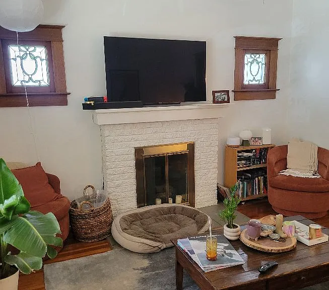 Decorative fireplace, beautiful hardwoods, and ceiling fan!
