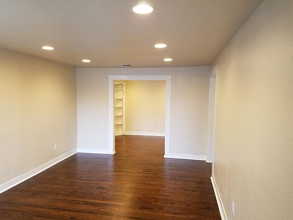Living room with dining room in the background. Modern recessed lighting throughout the home