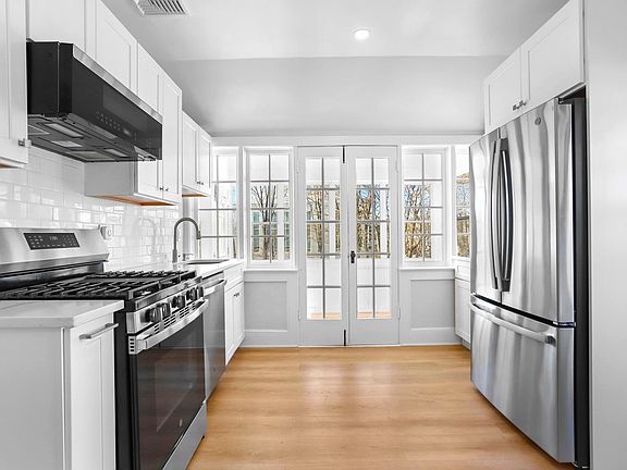 Stainless steel appliances/gas cooking stove, quartz countertops and french doors to sunroom