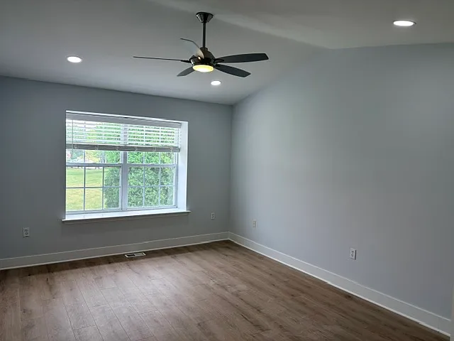 master bedroom with fan, recess lighing and luxury vinyl planks