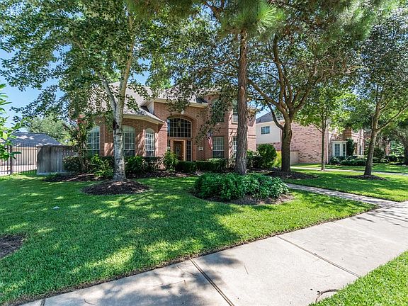 Home surrounded by mature landscaping including fruit trees.