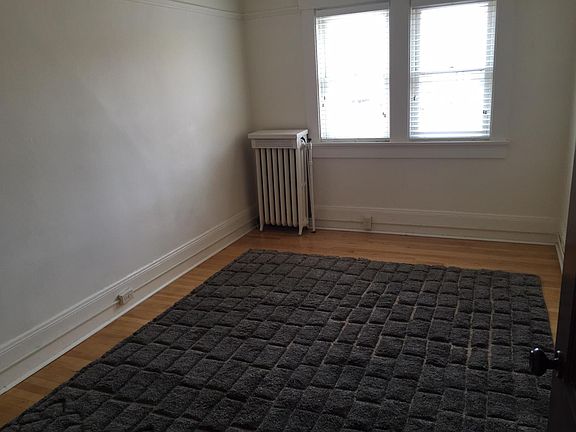 Bedroom with large, bright window. Hardwood floors. Carpet included. Spacious closet - not pictured.