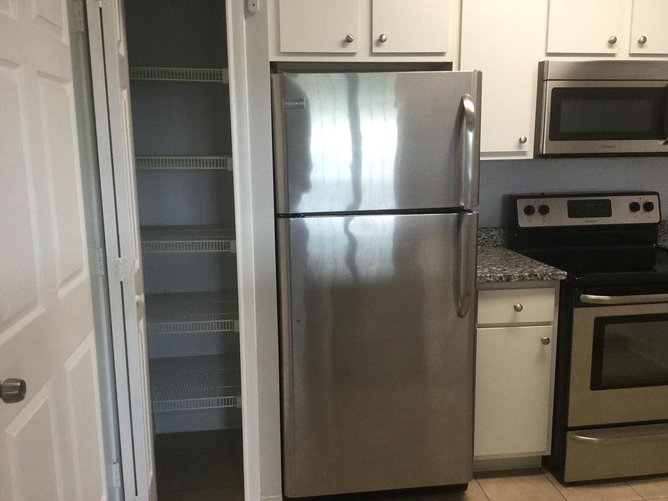 Pantry to the left of the stainless steel refrigerator.