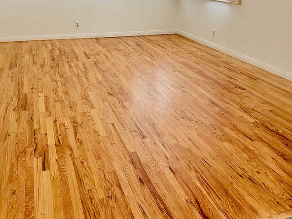 Bright living room space. The home features beautifully refinished solid hardwood floors throughout, complemented by a natural slate stone entry foyer.