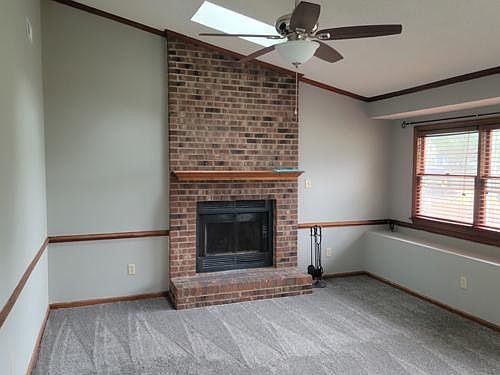 Living room with 2 skylights, ceiling fan, chair molding and real fireplace