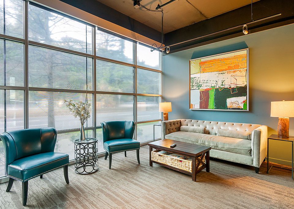 Clubhouse with carpeting, high ceilings, floor to ceiling windows, and sofas.