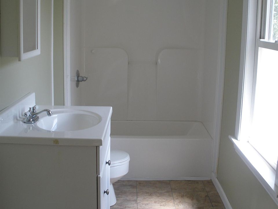 Tiled floor bathroom is filled with morning light.
