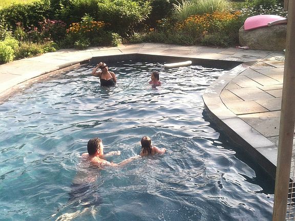 pool with family overlooking meadow. of wild flowers. Pool