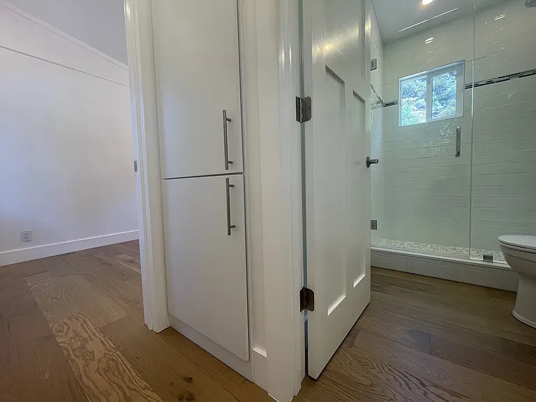 Ample storage in linen closet between bedroom and bathroom.