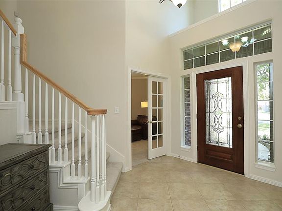 Light and bright 2 story entry with gorgeous beveled glass door and tile floors