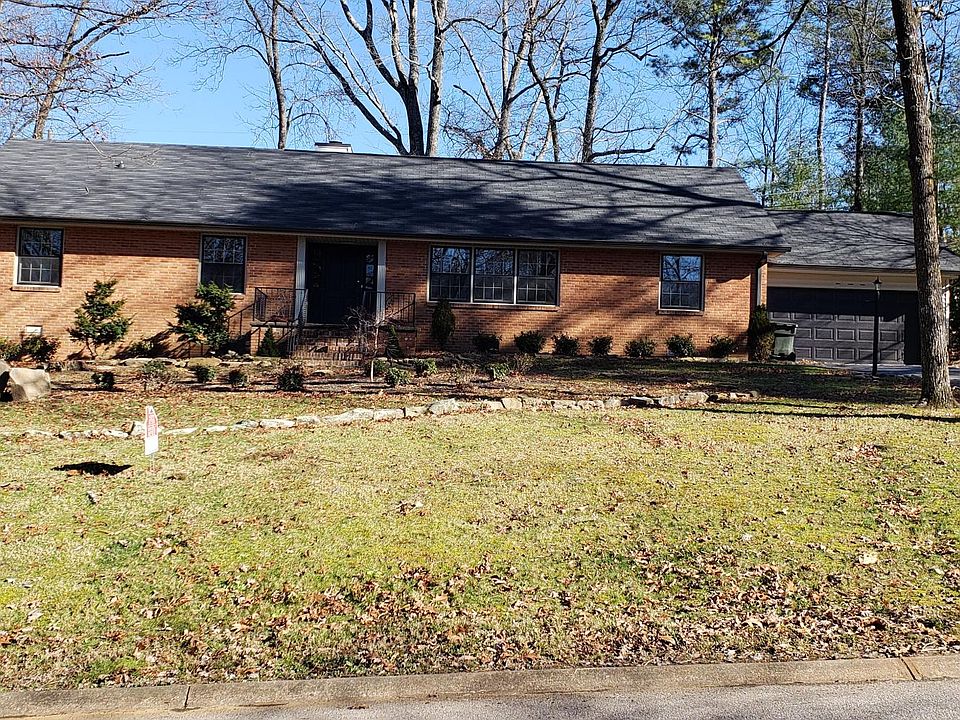 Front view of the house with beautiful brand new garage door and gutters just installed. The home sits on a hill with a nice view from the front porch. Lots of privacy with a wooded lot across the street and in back yard.