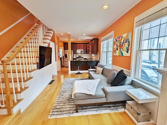 Alternate view of living area facing the kitchen. Clean, wireless tv mount hookup (mount stays with the home).