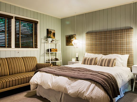 This single-story home has a spacious primary suite located on the opposite side of the house. The main bedroom has a king-size bed.