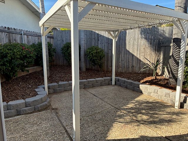private, fenced backyard with shady trellis