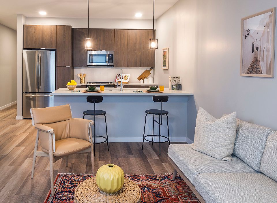 Spacious living room with open concept designer kitchen, espresso cabinetry, and stainless steel appliances