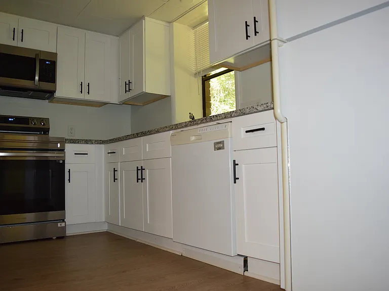 Kitchen with granite slab, window over sink, double bowl sink