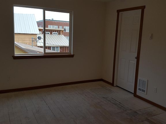Bedroom with double clothes rack in walk-in closet and window view of neighboring property. Laundry room including full sized washer and dryer is in adjacent room with a separate door.