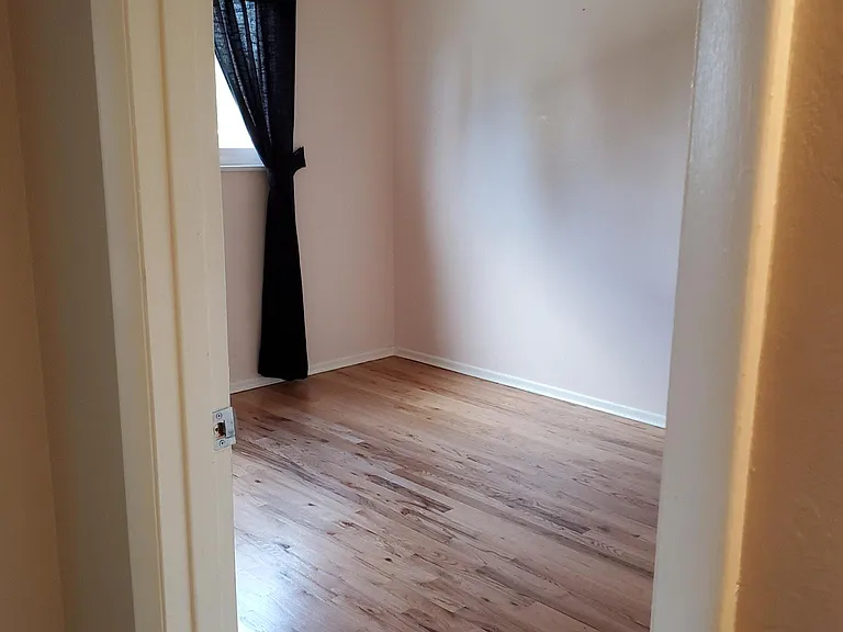 View of upstairs bedroom - window overlooks the back yard. There is an overhead fan/light. The pictured hardwood floor has just been replaced with new luxury vinyl flooring.