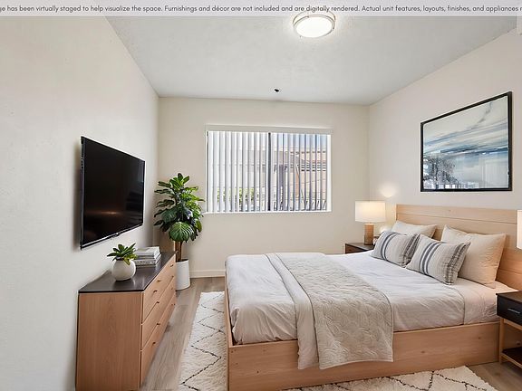 Spacious bedroom with updated flooring, natural light, and a clean modern design.