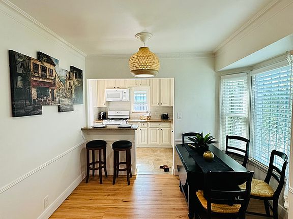 Table with extendable drop leaf (seats 4) and a two-seat bar stool area in dining area.