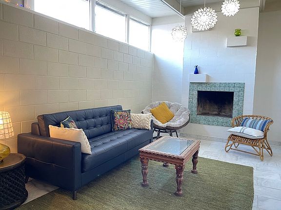 Living room with early morning Eastern sunlight in high windows. Leather sleeper sofa.