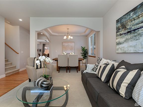 Seamless flow from the formal living room into the dining room! This area is perfect for seasonal gatherings, or birthdays.  Notice the dramatic archways and coffered ceiling that add architectural flair!