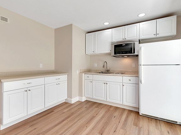 Kitchen includes 2-burner cooktop, microwave/convection oven, refrigerator, and garbage disposal