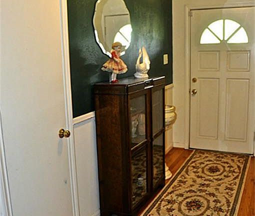 Front door with glass storm door opens to Foyer with Hard Wood flooring leading to Home.