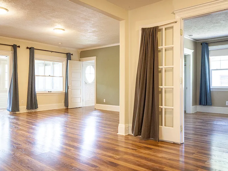 living and dining room with bedroom behind french doors