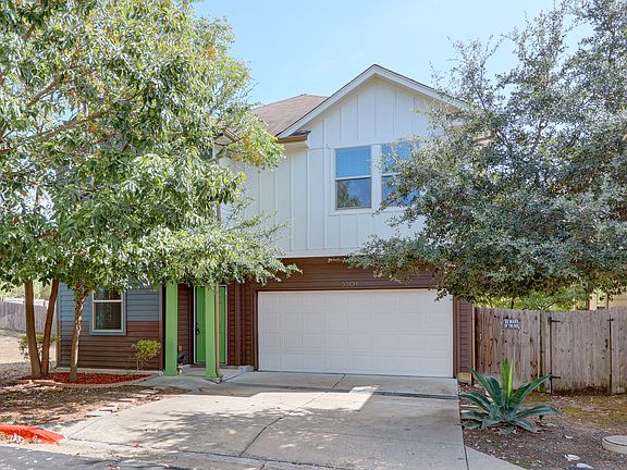 View of front of house with board and batten siding, a garage, and driveway