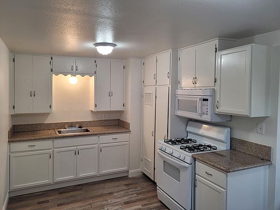 Kitchen with gas stove, over-the-range microwave oven, granite countertops and plenty of storage.