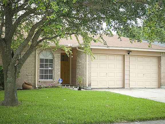 The nicely manicured lawn has a mature shade tree accenting the covered entry.