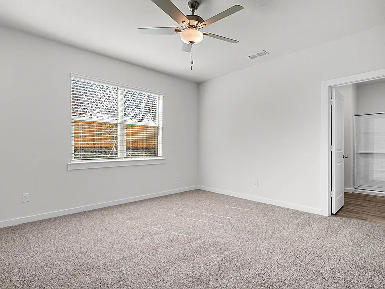 The spacious master bedroom has a window that lets in great, natural light and backyard views.